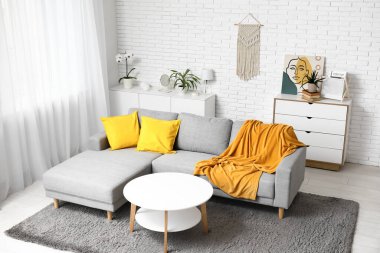 Rahat kanepesi, minderleri ve sarı ekoseli oturma odasının içi.