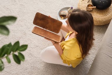 Sadhu tahtası olan genç bir kadın evde oturuyor.