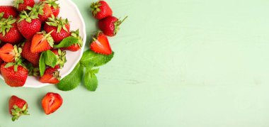 Yeşil zemin üzerinde taze çilek tabağı ve metin için yer var.