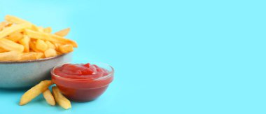 Lezzetli patates kızartması ve mavi arka planda ketçap dolu kaseler. Mesaj için yer var, yakın plan.