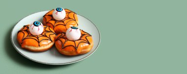 Cadılar Bayramı için yeşil arka planda gözlerle bir tabak lezzetli çörek.