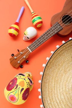 Şeker kafatasları, ukulele, marakas ve turuncu arka planda sombrero. Meksika 'nın Bağımsızlık Günü Kutlaması