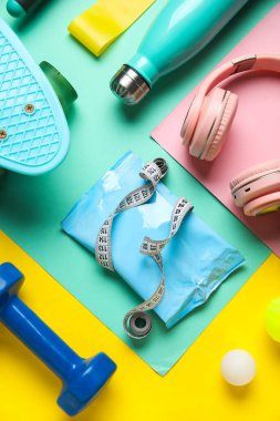 Sağlıklı atıştırmalıklar, modern kulaklıklar ve renkli spor ekipmanları ile kompozisyon