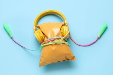 Modern kulaklıklı sağlıklı atıştırmalıklar ve renkli arka planda ip atlama