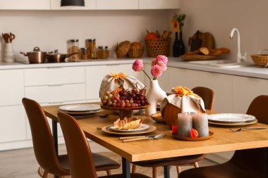 Yemek masası ve balkabağı servis edilen modern mutfağın içi.