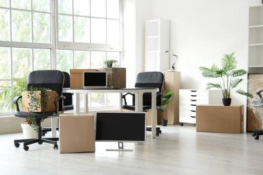 Taşınma gününde sandalyeleri, çiçekleri ve karton kutuları olan modern ofis.