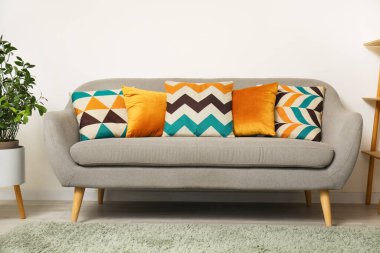 Modern oturma odasının içindeki yumuşak yastıklı rahat gri kanepe.