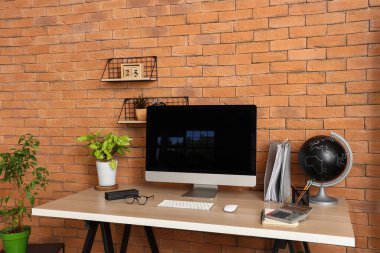 Ofisteki masasında kırtasiye ve küresi olan boş bilgisayar monitörü