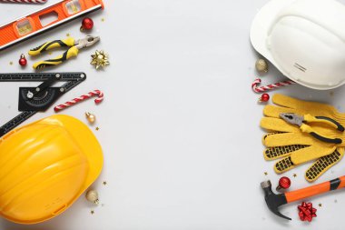 Aydınlık arka planda farklı yapı araçları ve Noel dekorasyonlarına sahip kompozisyon