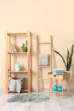 Odanın içinde masa, raf ve temiz havlular var.