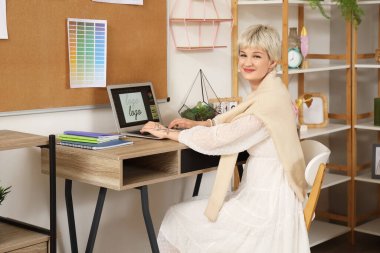 Ofiste dizüstü bilgisayarla çalışan güzel bir grafik tasarımcısı.