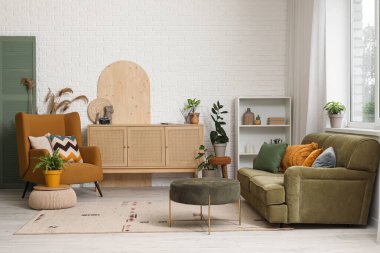 Koltuğu, çekmecesi ve kanepesi olan modern bir oda.