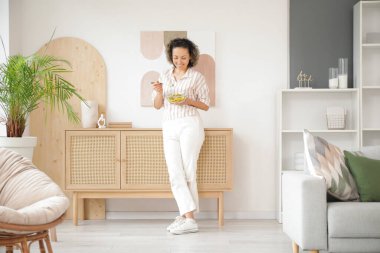 Evde sebze salatalı olgun bir kadın.