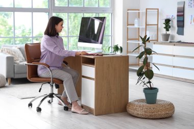 Ofiste bilgisayarla çalışan genç bir iç mimar.