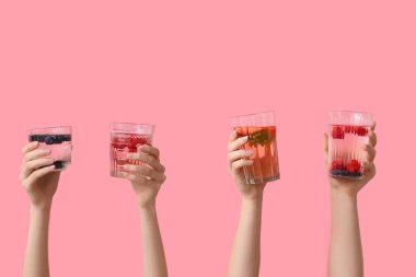 Pembe arka planda erimiş su olan birçok el