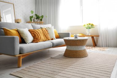 Kanepesi ve masası olan modern aydınlık oturma odasının içinde.