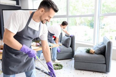 Erkek hademe yeni yıl partisinden sonra ofiste temizlik yapıyor.