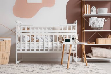 Oyuncak tavşanlı bebek monitörü çocukların yatak odasının içindeki masada.