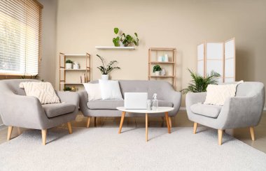 Masanın üzerinde kanepe, koltuk ve aroma spreyi olan bir oturma odası.