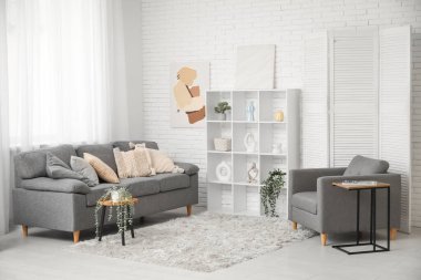 Tabloları, kanepesi ve koltuğu olan şık bir oturma odası.