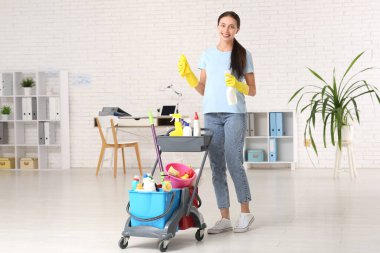 Ofiste tramvayla temizlik malzemesi taşıyan kadın hademe.