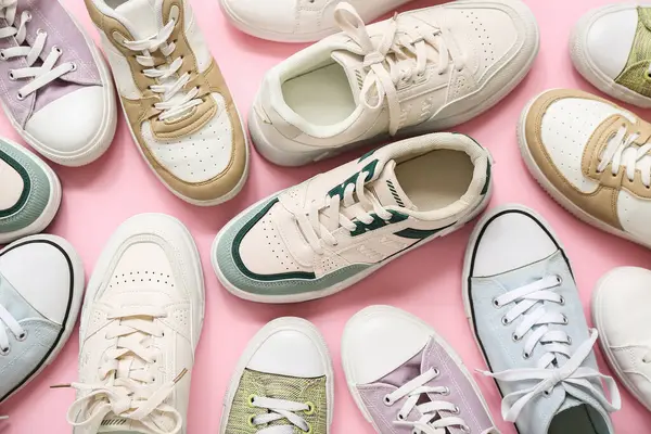 Pembe arka planda farklı şık spor ayakkabılar.