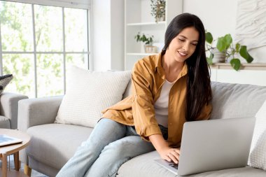 Güzel bir kadın sabahları kanepede oturuyor.