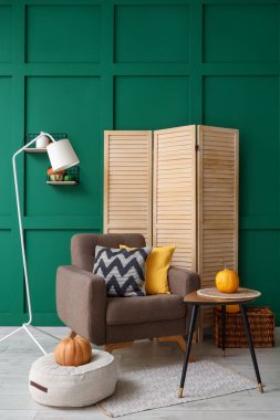 Sonbahar için dekore edilmiş modern oturma odası rahat koltuk, kahve masası ve katlanır ekran.