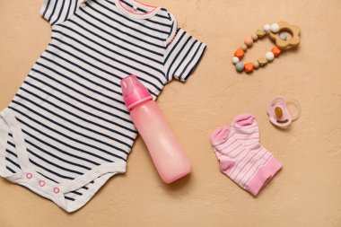 Bebek için süt, giysi ve aksesuarlar renkli arka planda.