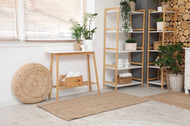 Banyonun içinde bank, raf ünitesi ve ev bitkileri var.