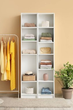 Renkli duvarın yanında şık giysileri rafa kaldırıyorum.