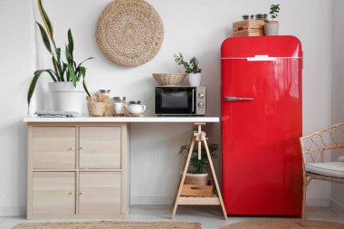 Mikrodalga fırını, ev bitkileri ve modern buzdolabı olan şık bir mutfak.