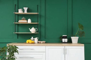 Mutfağın içinde tezgah, raf ve kahve makinesi var.