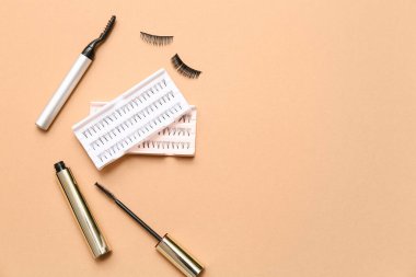 Bej arka planda rimel ve elektrik bigudiyle farklı takma kirpiklerin kümeleri
