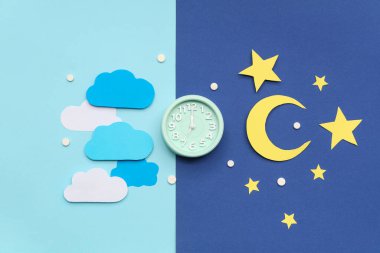 Kağıt bulutlu çalar saat, mavi arka planda yıldızlar ve ay. Melatonin kavramı