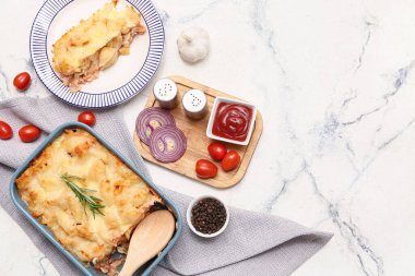 Biberiyeli fırında makarna, domates, soğan halkaları, biber ve mermer zemin üzerinde ketçap.