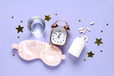 Bir bardak su, alarm saati, uyku maskesi ve mor arka planda konfeti içeren melatonin hapları.