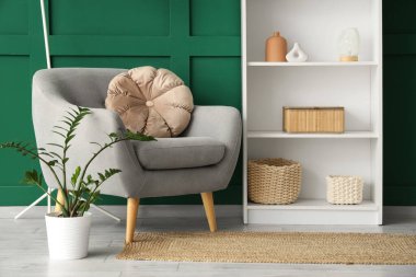 Koltuk, raf ünitesi ve lamba yeşil duvarın yanında. Yakın çekim.