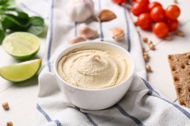 Bir kase lezzetli humus ve beyaz ahşap arka planda peçete. Yakın plan.