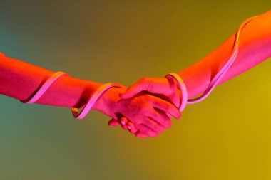 Renkli arkaplanda neon bandı olan tonlanmış kadın elleri