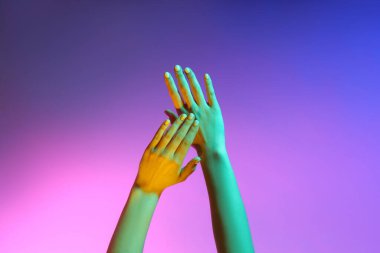 Renkli arka planda tonlanmış kadın elleri