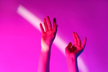 Pembe arka planda tonlanmış kadın elleri