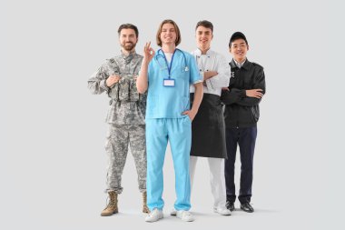 Aydınlık arkaplanda farklı mesleklerden üniformalı bir grup genç adam.