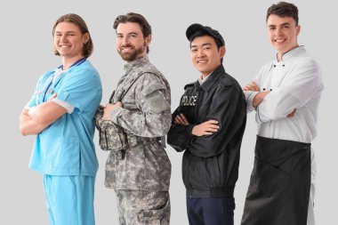 Aydınlık arkaplanda farklı mesleklerden üniformalı bir grup genç adam.