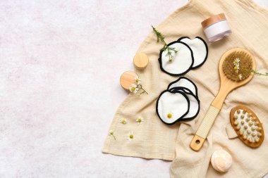 Pamuk pedler, banyo malzemeleri ve açık arkaplanda çiçekler.