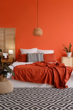 Yatağı, bitkileri ve katlanır perdesi olan şık bir oda.