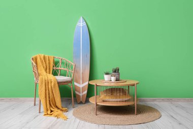 Koltuğu, sehpası ve sörf tahtası olan bir oda.