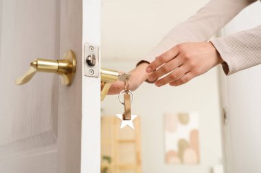 Kadın elleri kapıyı anahtarla açıyor, kapalı.