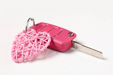 Beyaz arka planda pembe kalpli araba anahtarı, yakın plan.