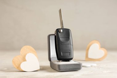 Araba anahtarıyla hediye kutusu ve grunge masasında kalpler.